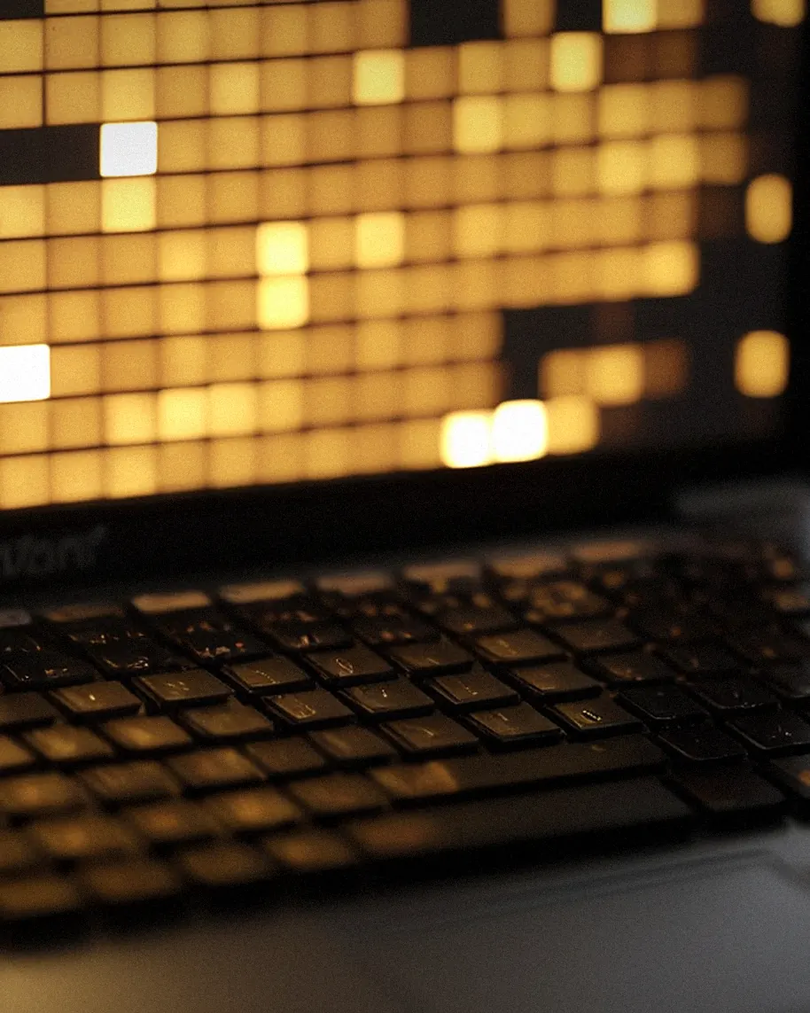 Laptop in einem dunklen Betriebsbüro mit unscharfem Einsatzplan auf dem Bildschirm